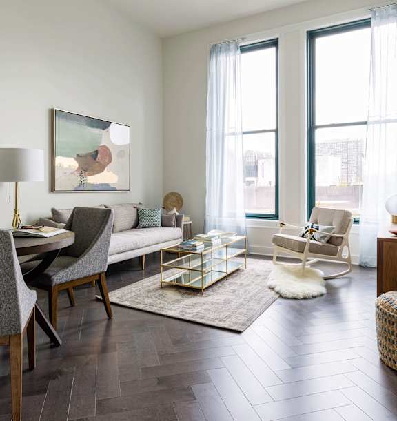A bedroom with a bed, chair, and nightstand. at The Pennsylvanian Apartments, Pittsburgh, Pennsylvania