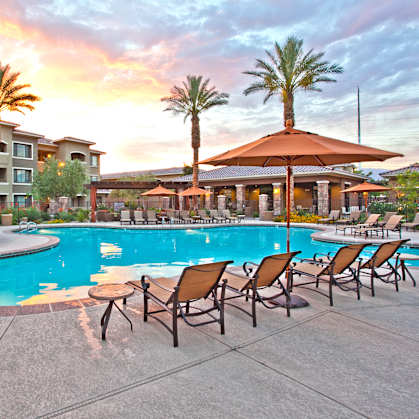a swimming pool at a resort with chairs and umbrellas