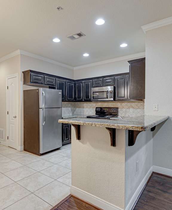 A kitchen with a refrigerator, microwave, and oven. at Logan Ridge Apartments, Apartments, San Marcos, TX