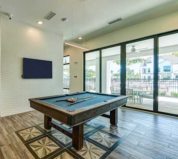 a paddle and a yellow ball on a pool table  at Imperial Crossing Luxury Apartment Homes, Bonita Springs, FL, 34134