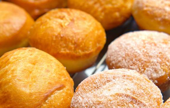 a tray of donuts covered in sugar