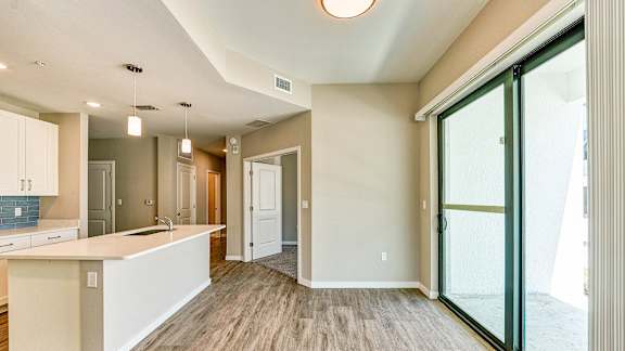 an open kitchen and living room with sliding glass doors at Imperial Crossing Luxury Apartment Homes, Bonita Springs, FL, 34134