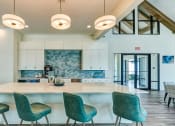 Thumbnail 39 of 49 - clubhouse with a kitchen and bar with blue chairs at Imperial Crossing Luxury Apartment Homes, Bonita Springs, FL