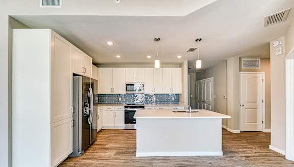 a renovated kitchen with white cabinets and a white counter top at Imperial Crossing Luxury Apartment Homes, Bonita Springs, FL