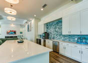 Thumbnail 40 of 49 - a kitchen with white cabinets and a white counter top at Imperial Crossing Luxury Apartment Homes, Bonita Springs, FL, 34134