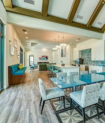 a dining room with blue tables and chairs and a kitchen with glass doors at Imperial Crossing Luxury Apartment Homes, Florida