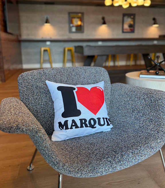 a woman sitting on a couch in a living room with a fireplace at The Marquis, Easton, PA 18042