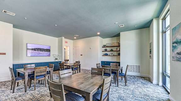 a dining room with tables and chairs and a large window at Imperial Crossing Luxury Apartment Homes, Florida