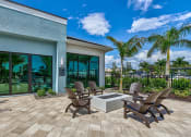 Thumbnail 15 of 49 - a patio with chairs and a fire pit at Imperial Crossing Luxury Apartment Homes, Florida