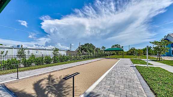 a walkway with a bench on the side of a sidewalk at Imperial Crossing Luxury Apartment Homes, Bonita Springs, Florida
