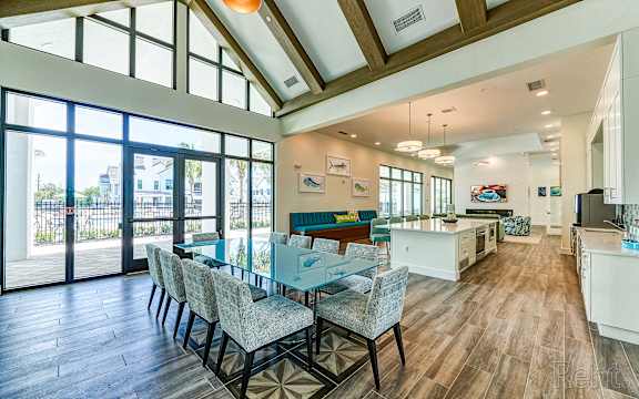 A dining room with a table and chairs with a view of the outside.