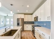Thumbnail 3 of 49 - a kitchen with white cabinets and stainless steel appliances at Imperial Crossing Luxury Apartment Homes, Florida