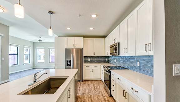 a kitchen with white cabinets and stainless steel appliances at Imperial Crossing Luxury Apartment Homes, Florida