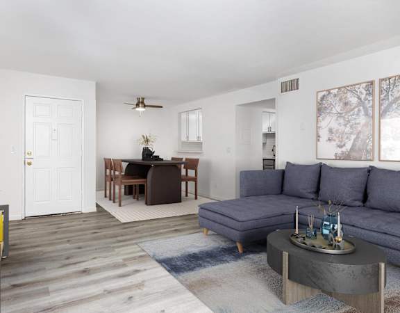 a living room with a blue couch and a dining room