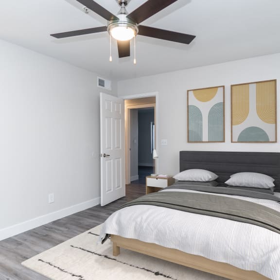 a bedroom with a large bed and a ceiling fan