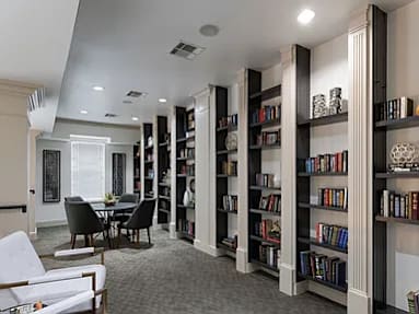 A room with a long bookshelf filled with books.