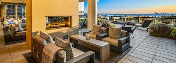 A patio with a fireplace and chairs. at Two Lincoln Tower Apartments, Bellevue, WA, 98004