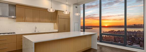 A kitchen at Two Lincoln Tower with a sunset view from the floor-to-ceiling window.