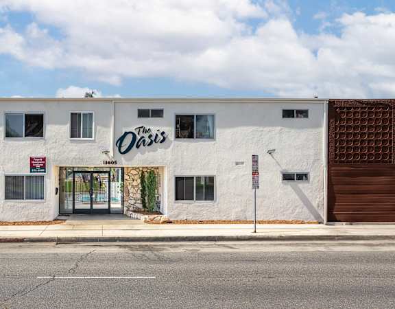 a white building with a sign on it on the side of a street