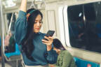a woman on a subway train looking at her phone
