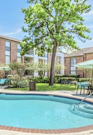 A swimming pool in front of apartment buildings.
