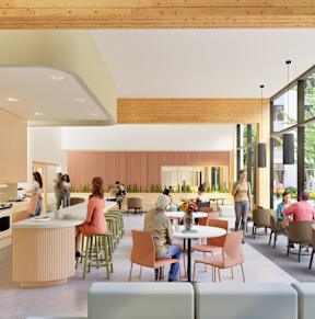 A group of people are gathered in a modern, open-concept kitchen and dining area.