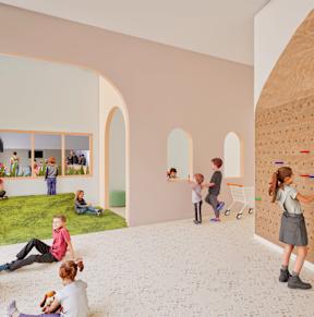A group of children are playing in a room with a climbing wall.