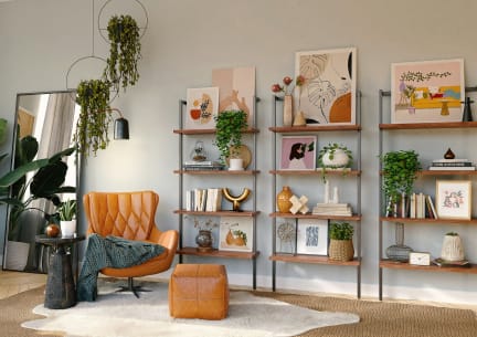 a living room with a chair and shelves with plants