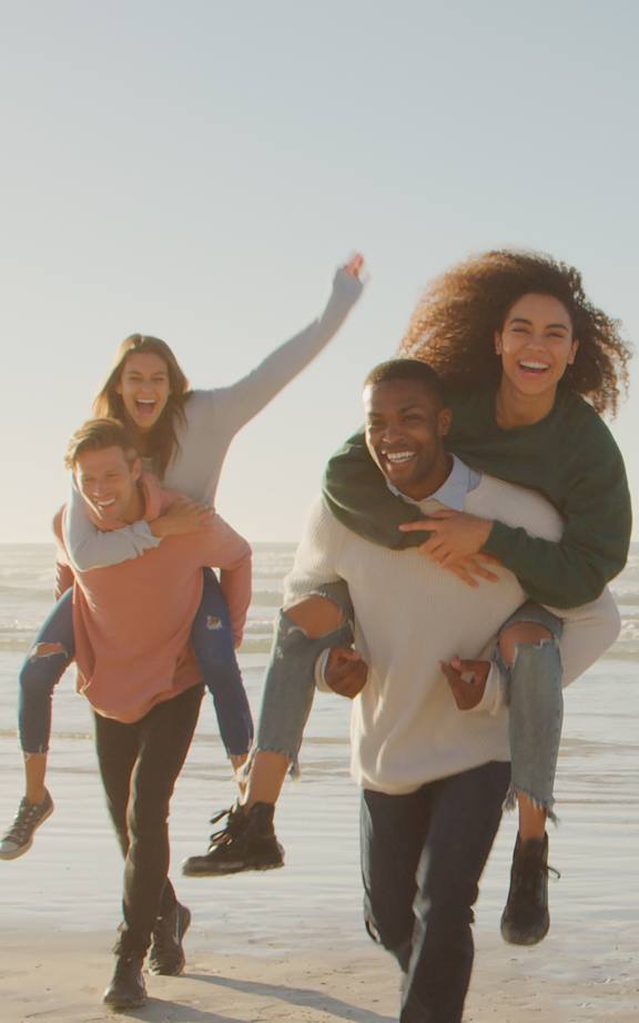 A group of friends are running and playing on the beach. at Seacoast Residences Apartments, Oakland, ME, 03904