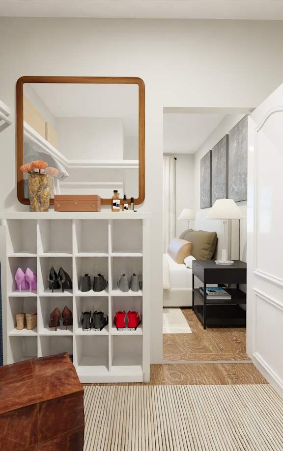 A hallway with a mirror and a shoe rack.