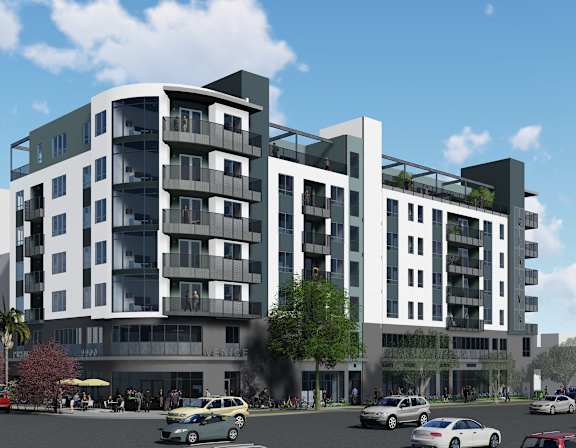 A modern apartment building with cars parked in front.