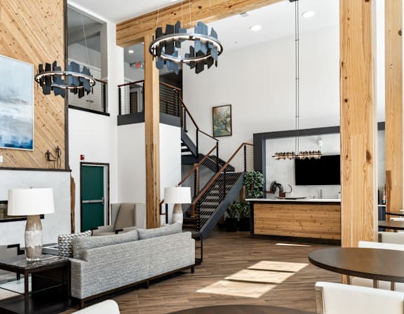 A modern living room with a grey couch, a coffee table, and a staircase.