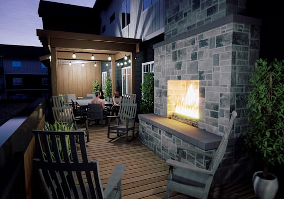A couple is sitting in a backyard with a fireplace.