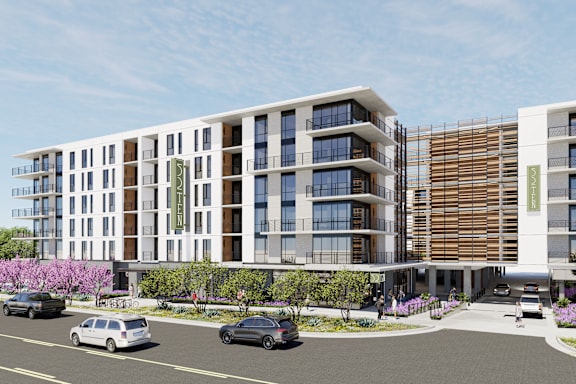 A modern building with a parking lot in front.