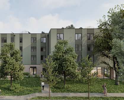 A modern apartment complex with greenery surrounding it.