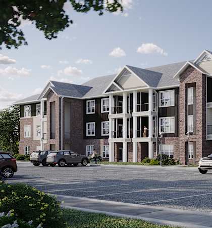 A modern apartment complex with cars parked in front.