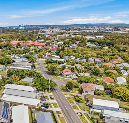 A bird's eye view of a residential area with houses and solar panels.