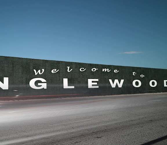 a sign that reads welcome on a wall next to a road