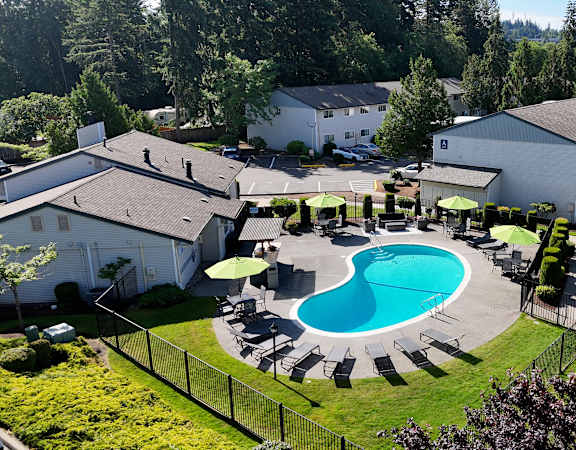 A pool surrounded by a fence and trees.