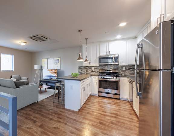 A modern kitchen with a refrigerator on the right side.
