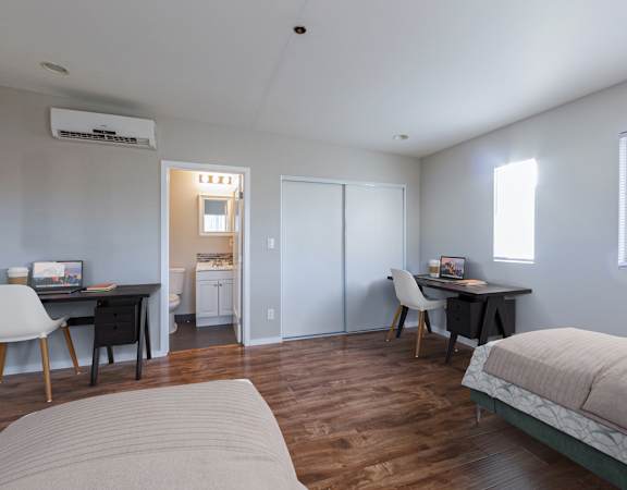 A bedroom with a bed, desk, and chair.