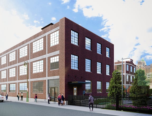 A red brick building with many windows is the main focus of this image.