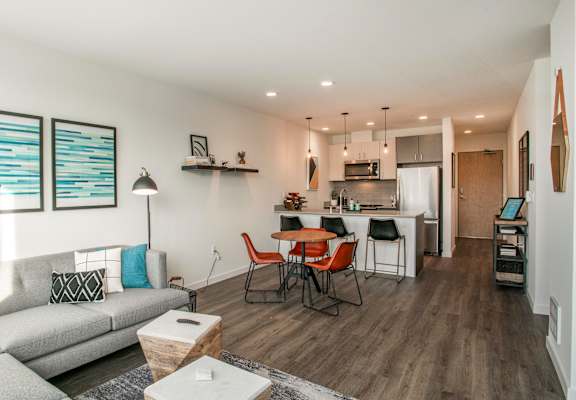 A modern living room with a grey sofa and a wooden dining table.at Axle, Seattle Washington