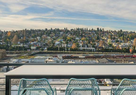 A table with chairs overlooking a cityscape.at Axle, Washington, 98119