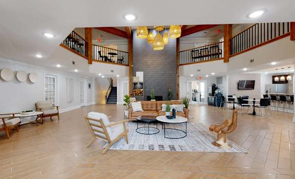 A spacious living room with a staircase and a fireplace.