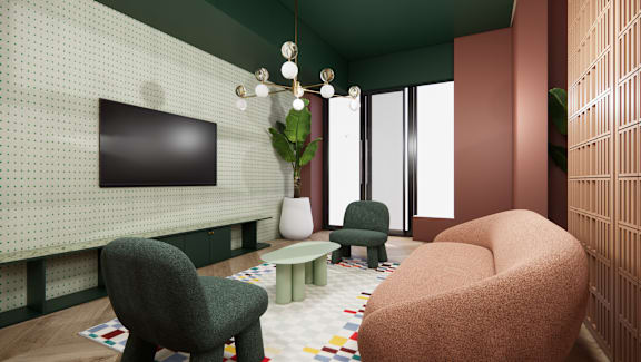 A living room with a green chair, a brown chair, and a flat screen TV mounted on the wall.