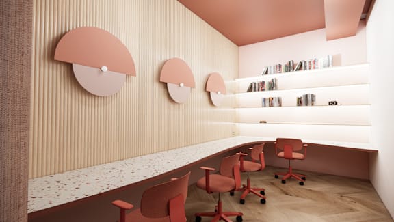 A room with a long table and chairs and a shelf with books.