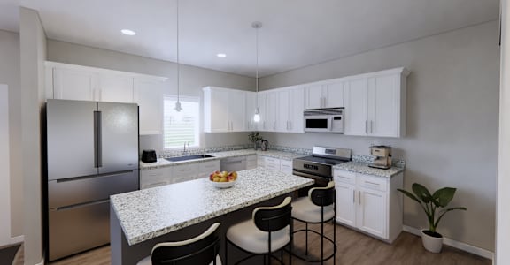 A modern kitchen with a granite countertop and stainless steel appliances.