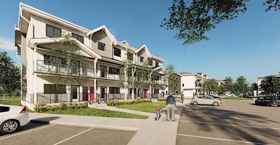A modern apartment complex with a parking lot in front.