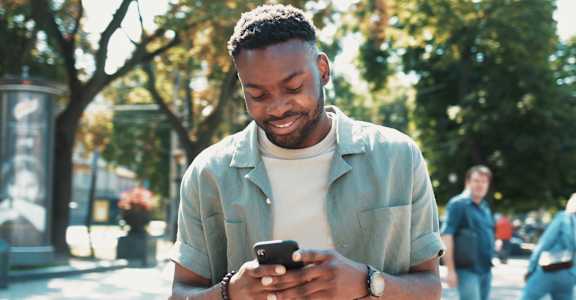 a man looking at his phone on the street